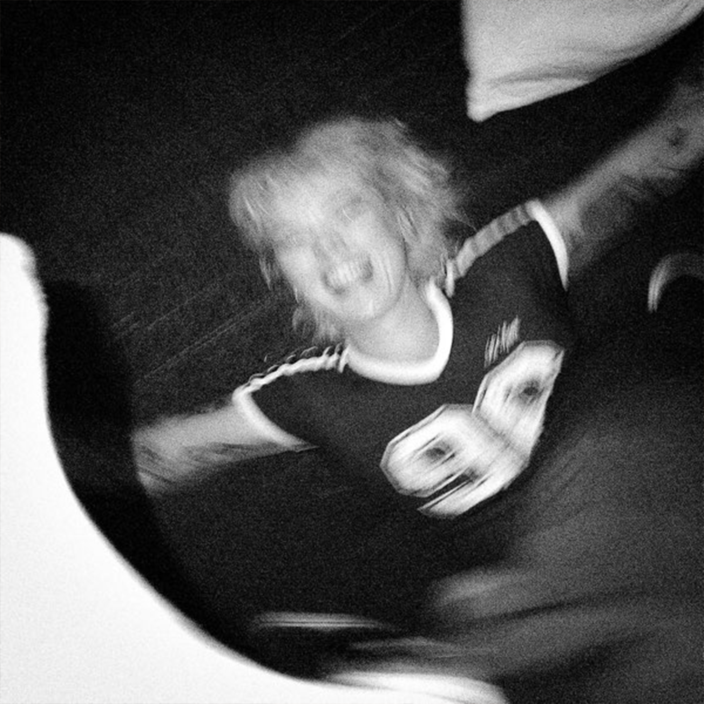 The cover of Betty Who's "Love Yourself" depicting the singer in black and white, spinning, out of focus, while smiling