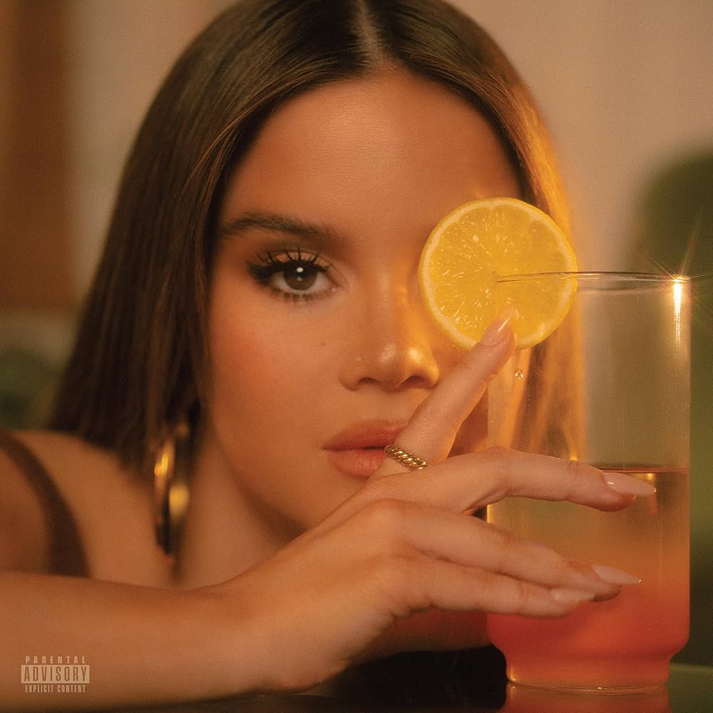 The cover of Maren Morris' "D R E A M S I C L E" depicting the singer holding an orange mixed drink with an orange slice on the rim. Her face is obscured by the drink.